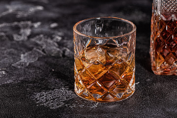 Whiskey on stone dark background.