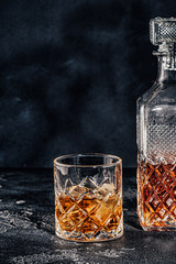Glass of the whiskey with a square decanter