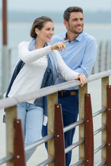 happy casual couple walking on the pier