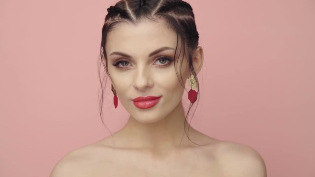 Brunette girl with pigtails on her head. Portrait of the model close-up. Perfect makeup. Beautiful hair, fashion video. Beautiful woman with jewelry. 4k 25fps
