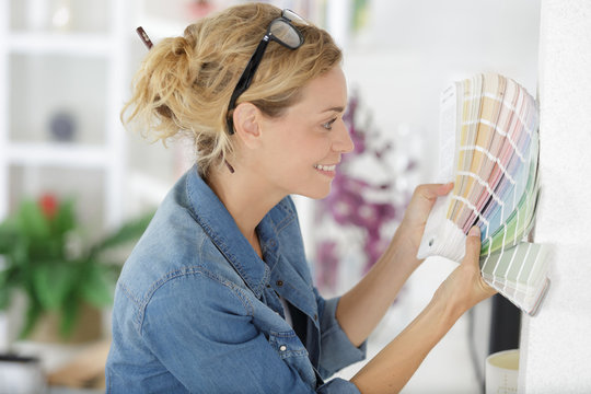 portrait of pretty blonde woman looking at color swatches
