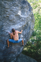 Man climbing boulder.