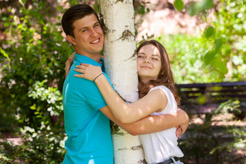 Young couple falling in love near the birch in the village at summer day.