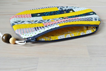 Patchwork quilted makeup bag with wooden beads on the table