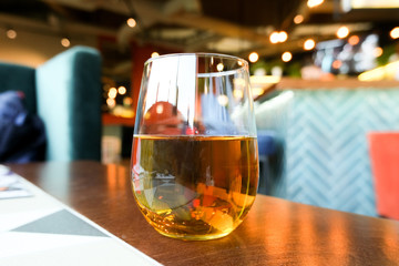 Apple juice in a glass beaker. Restaurant background.