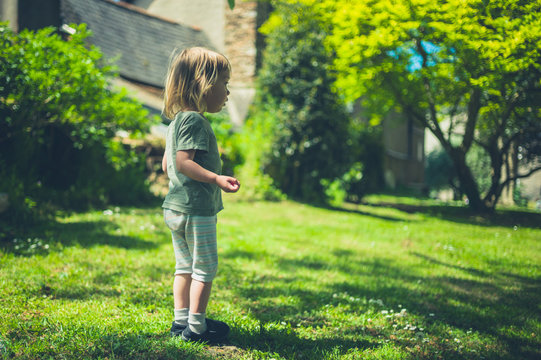 Little toddler standing on the grass in park