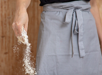 Mistress pours flour in the kitchen