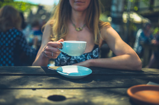 Woman drinking coffee in cafe outdoors