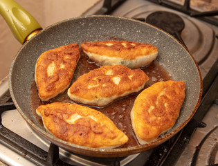 Patties are fried in oil in a pan