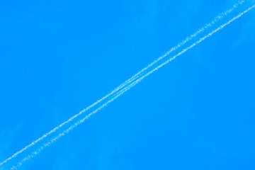 White contrail cloud on the blue sky.