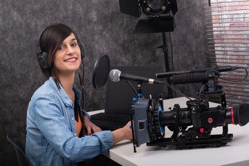 Young woman video editor working in studio