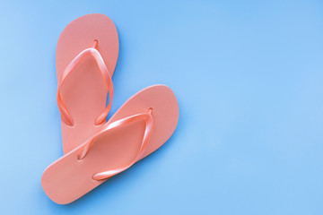 Living coral flip flops on a blue background. Color of the year 2019. Living coral. Place for text.