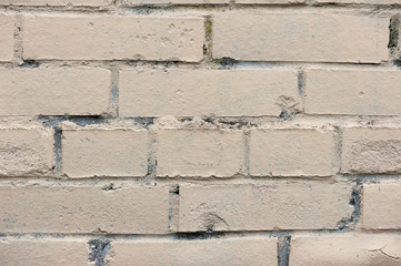 Old painted beige color weathered stained brick wall