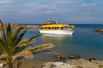 small ship with tourists enters the quiet harbor at the Greek fishing village of Sissi