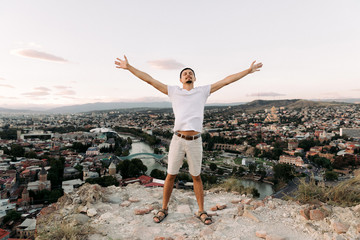 young man on the background of panoramic view of Tbilisi city. © producer