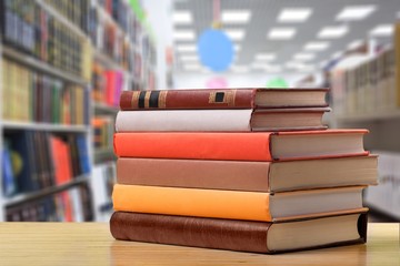 Stack of school books on library background