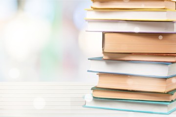 Stack of colorful books on white desk