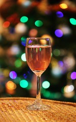 Glass of wine closeup Christmas bokeh light interior