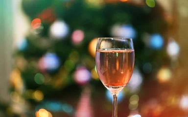 Foto op Plexiglas Glass of wine closeup Christmas bokeh light interior © wandeaw