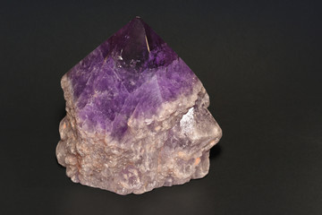 Large, single amethyst crystal on a dark background.