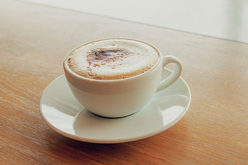Cup of coffee cappuccino on wooden bar in cafe.