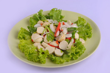 Spicy salad fish ball in a white dish with chopsticks on white background