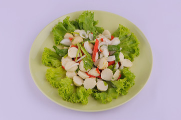 Spicy salad fish ball in a white dish with chopsticks on white background