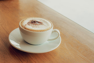 Cup of coffee cappuccino on wooden bar in cafe.