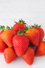 A Pile Of Healthy Scottish Strawberries on a White Plank Board.