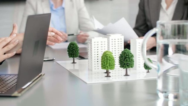 Architectural model on the table and architects in the background