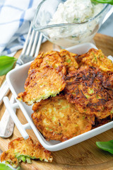 Zucchini fritters in a small white pot.