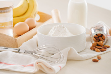 ingredients and tools to make banana cake on white background