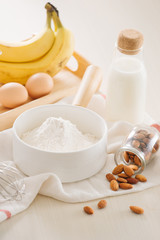 ingredients and tools to make banana cake on white background