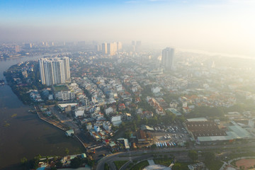 Obraz premium Top View of Building in a City - Aerial view Skyscrapers flying by drone of Ho Chi Mi City with development buildings, transportation, energy power infrastructure. include Landmark 81 and blue sky ,