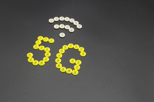 Creative pattern of 5G and WIFI number symbols made up of many round plastic clothes buttons on a black background