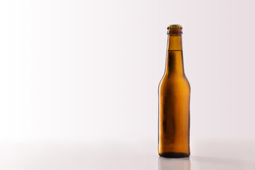 Beer bottle filled and closed on glass table white background.