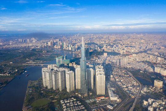 Top View of Building in a City - Aerial view Skyscrapers flying by drone of Ho Chi Mi City with development buildings, transportation, energy power infrastructure. include Landmark 81 and blue sky ,
