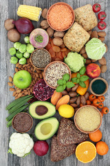 Health food for a high fibre diet with fruit, vegetables, legumes, nuts, whole grain bread rolls, seeds and grains. Foods with antioxidants, anthocyanins, vitamins and minerals. Top view.