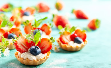 Summer berry tartlets  with cream and fresh berries.