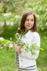 Beautiful girl blowing. portrait of a girl in a blooming apple tree.