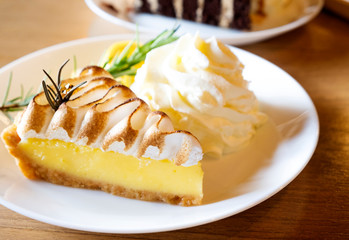 Lemon tart and whipped cream on a wooden table