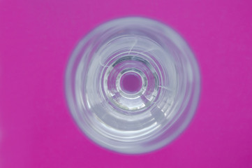 glass wineglass with reflections on pink vivid background. view from above. abstraction