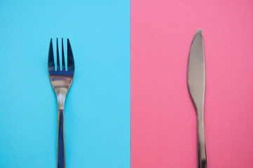 fork and knife on blue and pink background