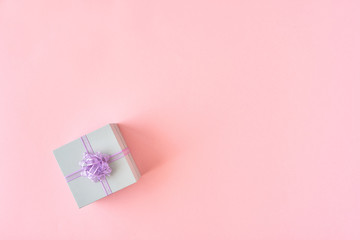  Gift box with ribbon and bow on color background and space for text. Top view