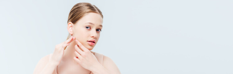 Obraz na płótnie Canvas upset teenage girl touching pimple on face, panoramic shot
