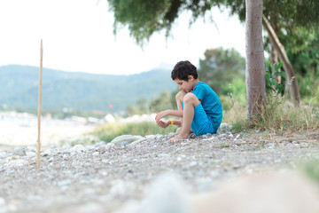 Boy is waking and playing on the beach