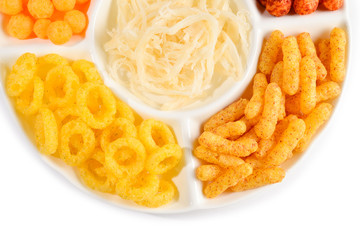 Mix of snacks on a white plate isolated on white.
