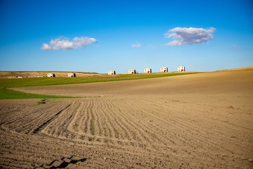 Fototapeta na wymiar Agricultural landscape of Murgia plateau with abandoned farmhouses in the background. Apulia region, Italy