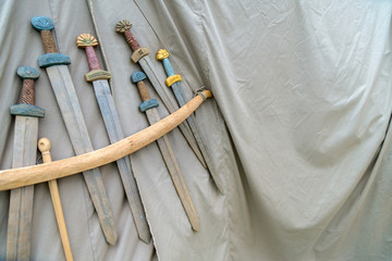 Medieval weapons for close combat displayed on grey fabric textu