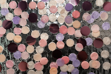 Pastel colored confetti on shiny foil background. Festive backdrop.